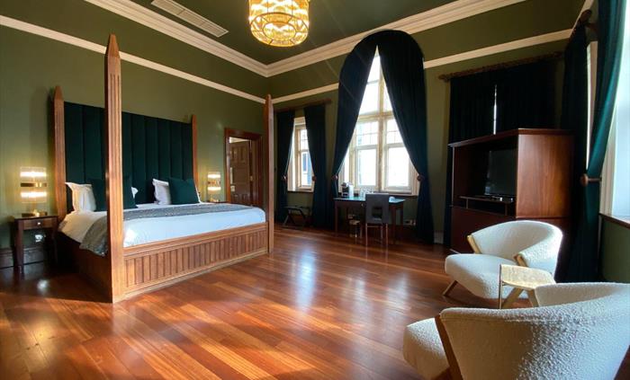The Rajah of Sarawak suite boasts a huge four-poster bed, two comfy chairs and small coffee table, an additional table and chair and large television,